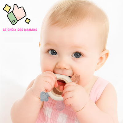 Baby biting a MimiAnneau silicone and wood teething ring with decorative shapes.