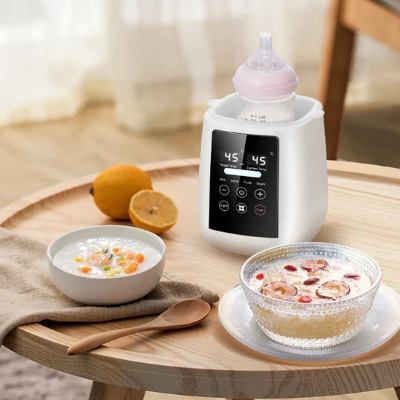 White mutualdropshopping bottle warmer heating a baby bottle on a wooden table next to bowls of porridge.